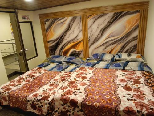 a bedroom with a bed with a floral comforter at Hotel Antonela Amorim in Barrio Centenario