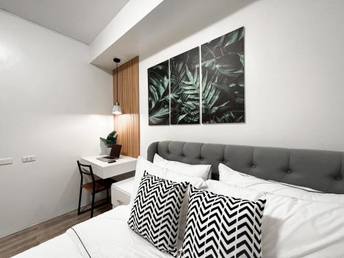 a bedroom with a bed with black and white pillows at Zara at Mesavirre Bacolod in Bacolod