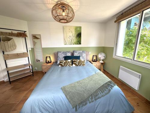 a bedroom with a large blue bed with two pillows at Vent d'ouest in Messanges