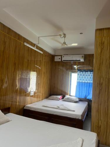 a room with two beds in a small room at Panthanibas momochitte in Bakkhali