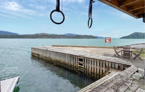 a dock with a swing hanging over a body of water at 3 Bedroom Nice Home In Os in Oma
