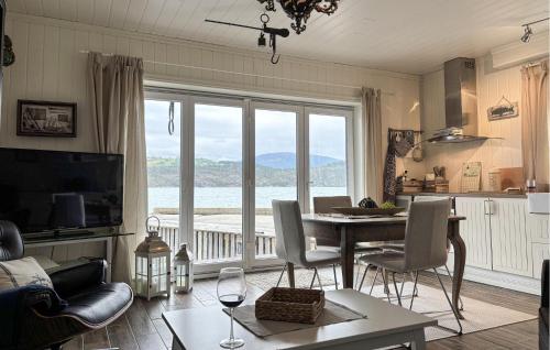 a living room with a table and a large window at 3 Bedroom Nice Home In Os in Oma