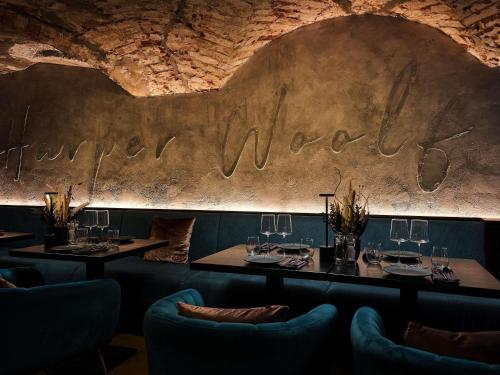 a dining room with tables and chairs and a wall with the wordiversary at Pullman Riga Old Town - Renovated 2025 in Riga