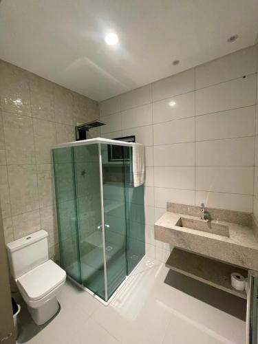a bathroom with a glass shower and a toilet at Pousada Recanto do Oásis in Triunfo