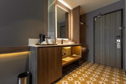a bathroom with a sink and a mirror and a shower at Costa Hotel Nilai in Nilai