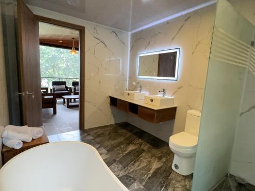 a bathroom with a toilet and a sink and a mirror at SAMAY FOREST- MASHPI AMAGUSa in Mashpi