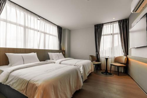 a hotel room with two beds and a window at Costa Hotel Nilai in Nilai