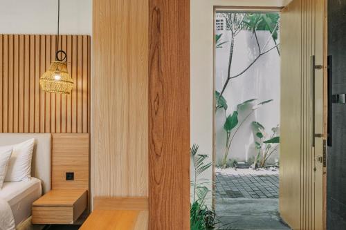 a bedroom with a bed and a door to a courtyard at Villa Di Bali in Yogyakarta