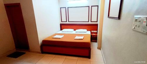a small room with a bed with two towels on it at Seethal Residency in Kattappana