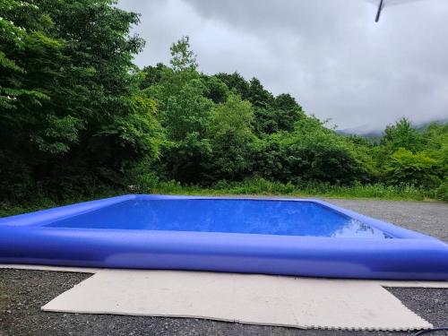 a blue pool sitting on the side of a road at Yufuin Besso Shikisai Hotel in Yufu