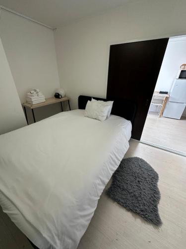 a bedroom with a white bed and a rug at Panda Home Umeda 01 in Osaka