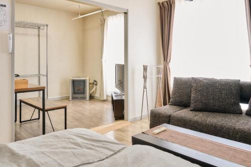 a living room with a couch and a table at Bird Heights 101 in Furano