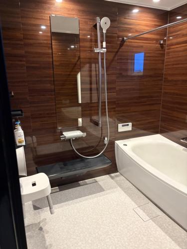 a bathroom with a shower and a bath tub at Sugi Nest Rausu-villa- in Rausu