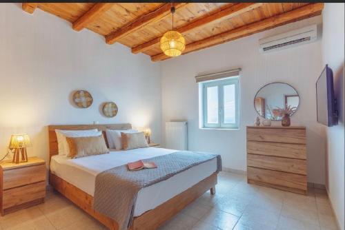 a bedroom with a large bed and a mirror at Morning glow villa in Antiparos