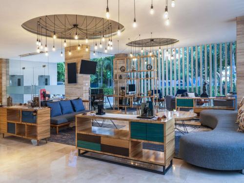 a living room with couches and a table at Mercure Jakarta Cikini in Jakarta