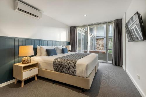 a bedroom with a large bed and a window at Wyndham Resort Torquay in Torquay