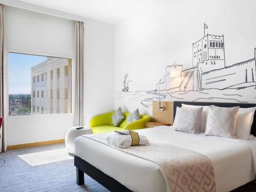 a bedroom with a bed with a drawing on the wall at Mercure Sohar in Sohar