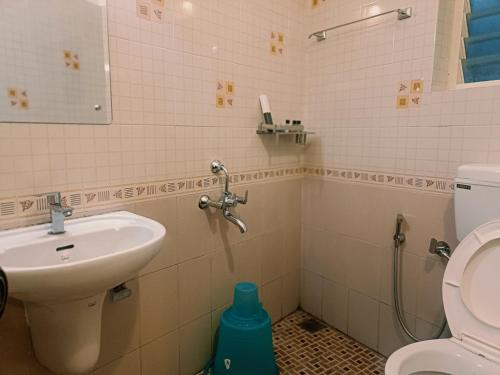 a bathroom with a sink and a toilet at The Thekkady Haritham Residency in Thekkady