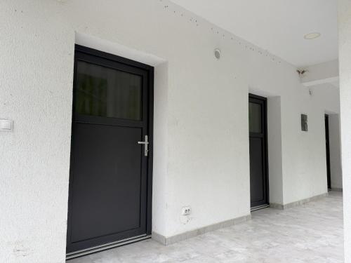 a black door on the side of a building at Camping Colibita in Colibiţa