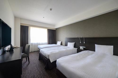 a hotel room with two beds and a flat screen tv at KKR Hotel Nagoya in Nagoya