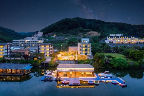 a city at night with boats in the water at Gapyeong the Bay Resort in Gapyeong