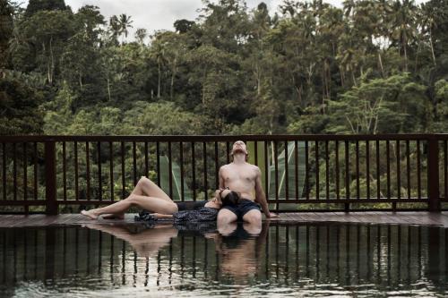 a man and a woman laying in the water at Nandini Jungle by Hanging Gardens in Payangan