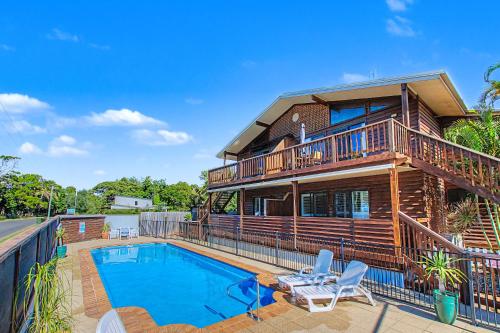 a house with a swimming pool and a deck at Boat Harbour Stays in Hervey Bay