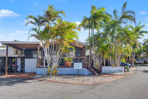 a house with palm trees in front of it at Boat Harbour Stays in Hervey Bay