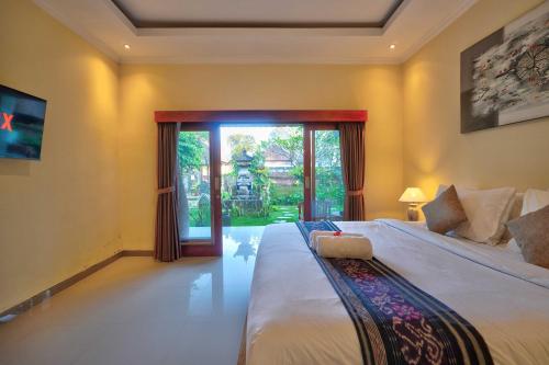 a bedroom with a large bed and a large window at Aruna House in Ubud