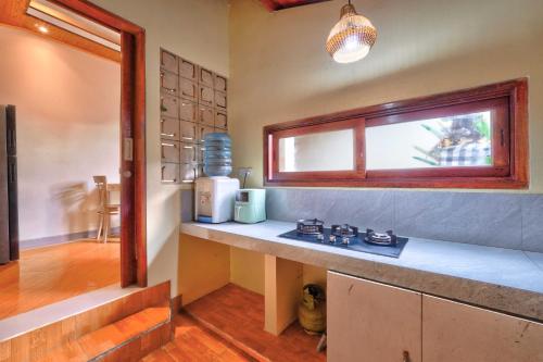 a kitchen with a counter top with a window at Aruna House in Ubud