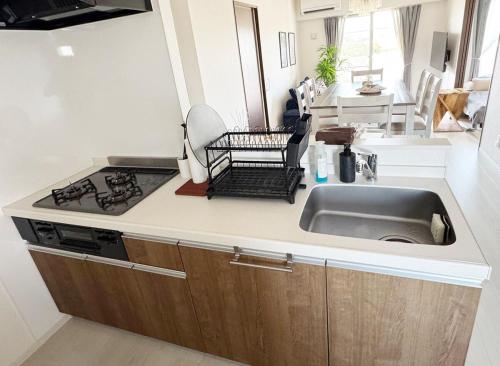 a kitchen with a sink and a stove at Maison deLacue in Uruma