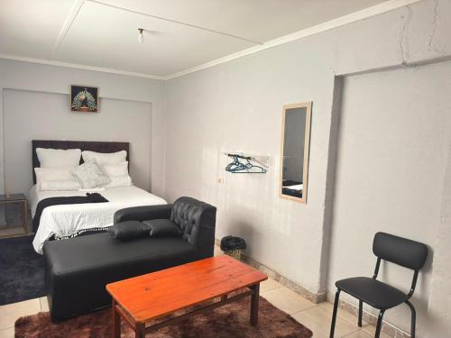 a room with a bed and a couch and a table at 399 Place in Umtali