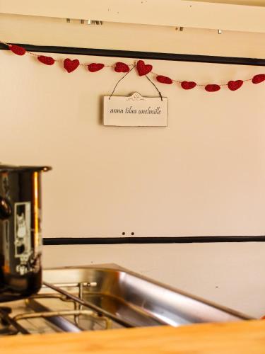 a sign on a wall above a kitchen sink at Camper Somá in Muonio