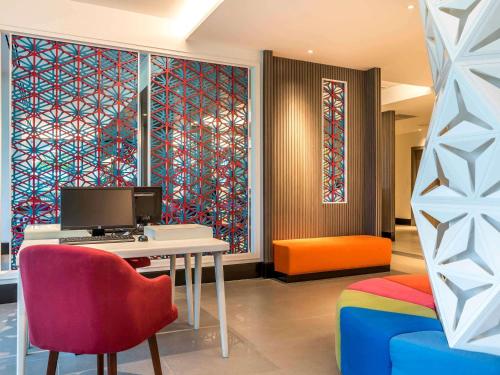 a room with a desk with a computer and a chair at Ibis Styles Phuket City in Phuket