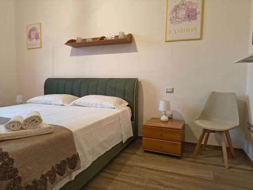 a bedroom with a bed and a chair and a table at MaGi-A apartment in Cecina
