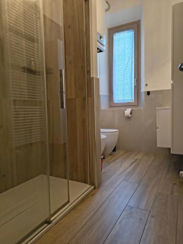 a bathroom with a shower and a toilet and a window at MaGi-A apartment in Cecina