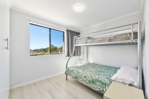 a bedroom with two bunk beds and a window at Forsters Bay Haven in Narooma
