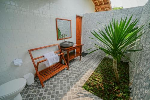 a bathroom with a sink and a toilet and a plant at Villa Kebun Pala in Borobudur
