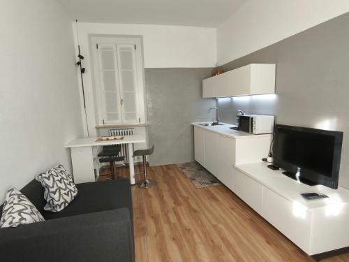 a living room with a couch and a tv and a desk at La Terrazza in Centro in Treviglio