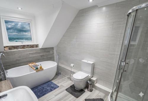 a bathroom with a tub and a toilet and a sink at Halekulani Devon Homestay in Torquay