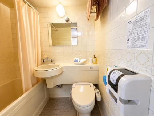 a small bathroom with a sink and a toilet at 和洲館ホテル in Gyōda