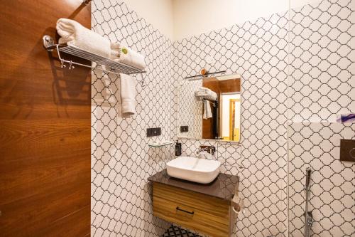 a bathroom with a sink and a mirror at Tiger Aura Resort in Rāmnagar