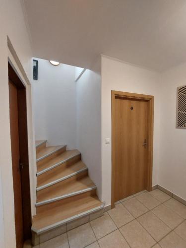 a staircase in a room with a wooden door at Penzión Ostrva in Vyšné Hágy