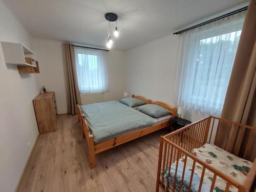 a bedroom with a bed in a room with windows at Penzión Ostrva in Vyšné Hágy