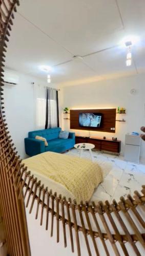 a living room with a bed and a blue couch at Casa résidences in Bouaké