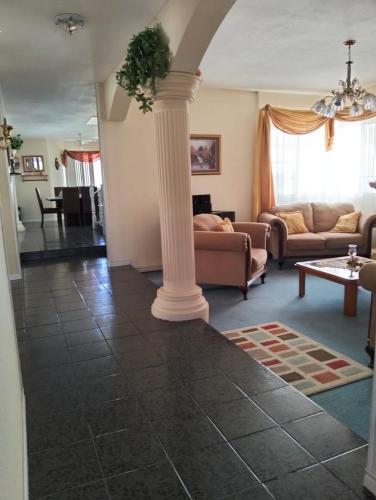 a living room with a couch and a column at House in a private gated community in Chihuahua