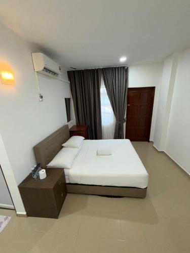 a hotel room with a bed and a window at Amzar Motel Cenang in Pantai Cenang