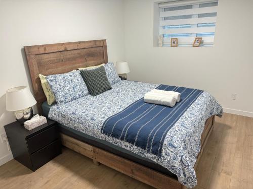 a bedroom with a bed with a blue blanket and pillows at Kris Anclam in Langley