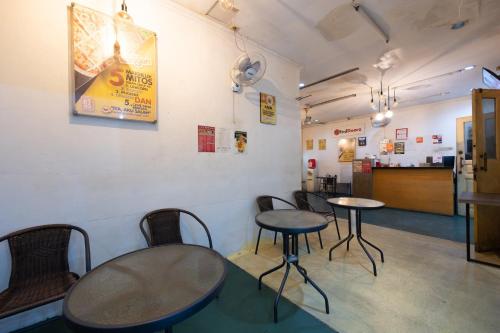 a room with tables and chairs in a restaurant at RedDoorz at Taman Galaxy Bekasi in Bekasi