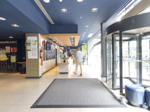 a person walking down a hallway in a shopping mall at ibis budget Blumenau in Blumenau